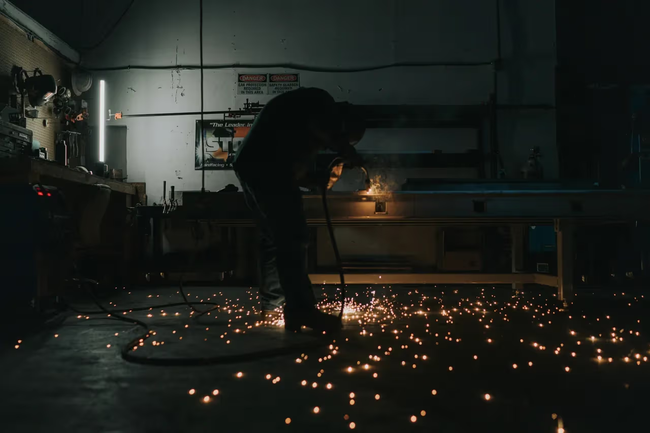 Welder working with sparks in workshop